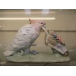 A Lladro figure of a parrot pushing a wheelbarrow full of flowers CONDITION REPORT: