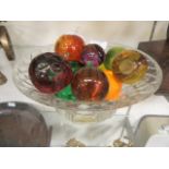 A cut glass bowl containing an assortment of glass fruit