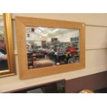 A wooden framed rectangular wall mirror