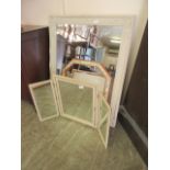 An ornate cream framed bevel glass mirror along with a triple vanity mirror and one other