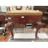 An early 20th century mahogany music stool with cabriole supports