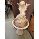 A white painted stoneware bird bath having a cherub design