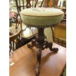 A Victorian walnut music stool having a floral rose design embroidered seat