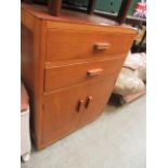 A mid-20th century teak cabinet having two drawers above two cupboard doors