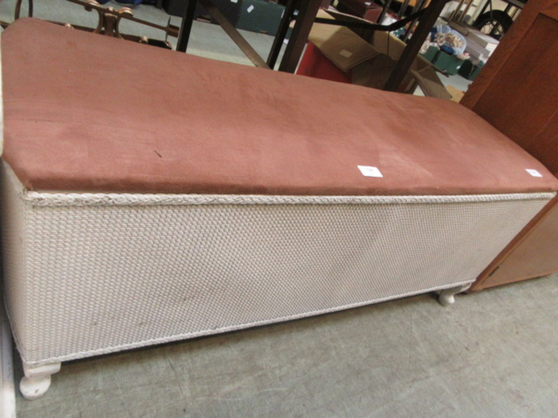 A white painted soft wicker ottoman