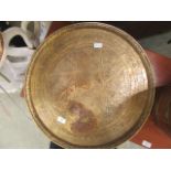 A circular brass engraved tray
