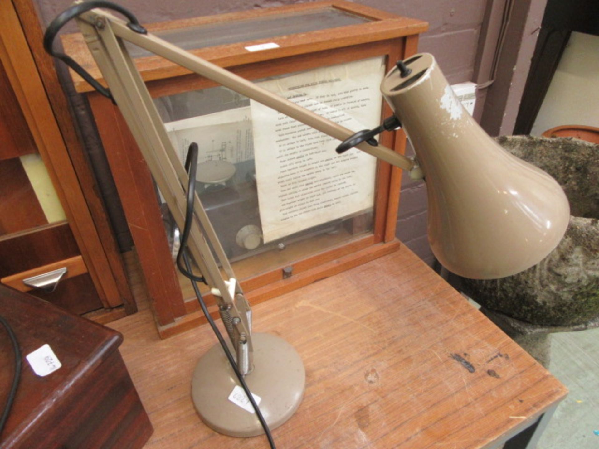 A light brown angle-poise style lamp