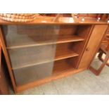 A mid-20th century teak bookcase with sliding glass doors and cupboard door