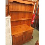 A modern pine dresser having plate rack to top,