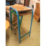 A blue metal tubular stool together with a matching green stool