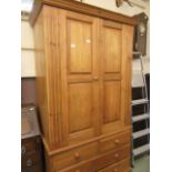 A waxed pine two door wardrobe having two short drawers over two long drawers to base