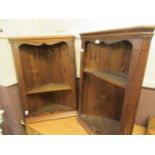 A pair of stained pine corner wall mounted cupboards