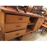 A waxed pine dresser base having open storage flanked by three drawers