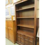 An Ercol full height bookcase with two cupboard doors to base