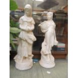 A pair of painted garden ornaments of young ladies