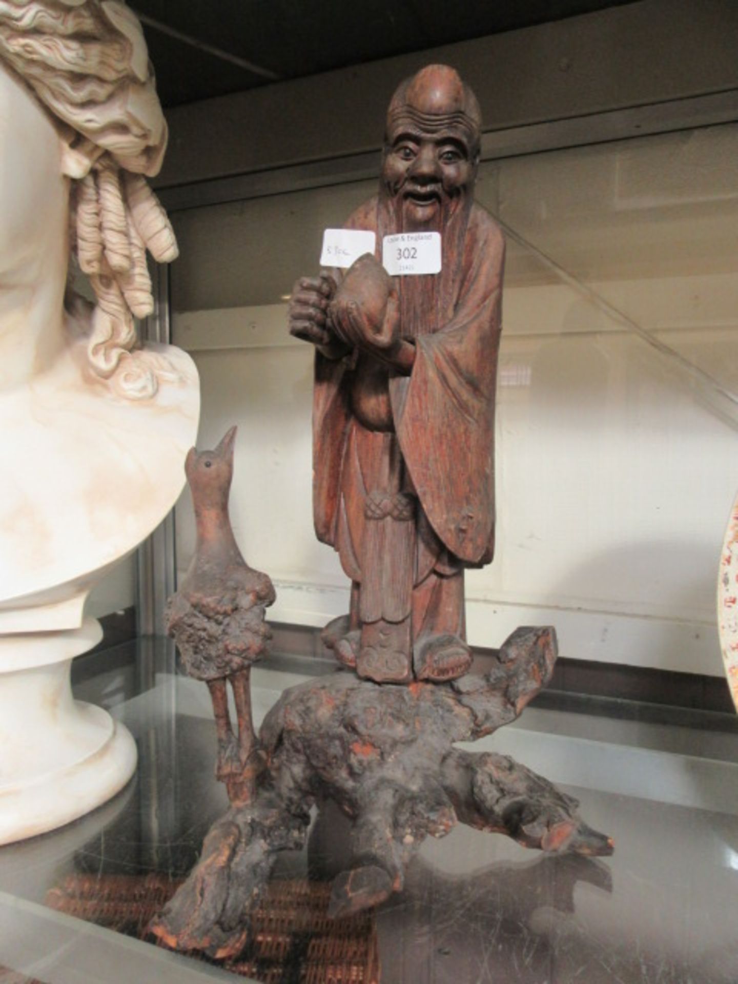An eastern carved figure of gentleman with bird