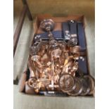 A tray containing a plated candelabra, brass flatware, boxed flatware,