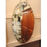 A mid-20th century bevel glass oval wall mirror