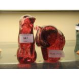 Two red glass animals one in the form of dog,