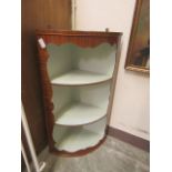 A reproduction mahogany wall hanging bow fronted corner cupboard