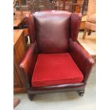 An early 20th century red leather upholstered wing armchair