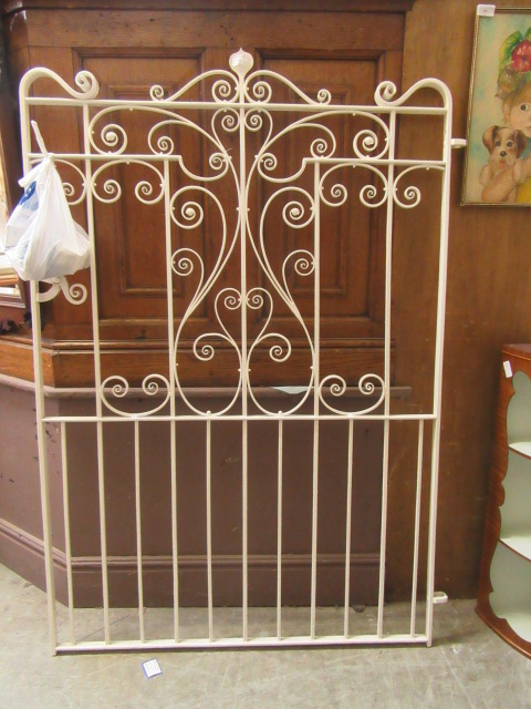 A white painted wrought iron garden gate