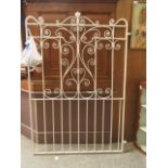 A white painted wrought iron garden gate