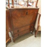 A reproduction walnut cabinet having a pull down flap with two drawers below