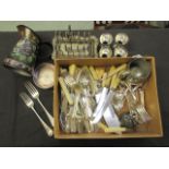 A box containing an assortment of flatware, egg cups, toast rack,