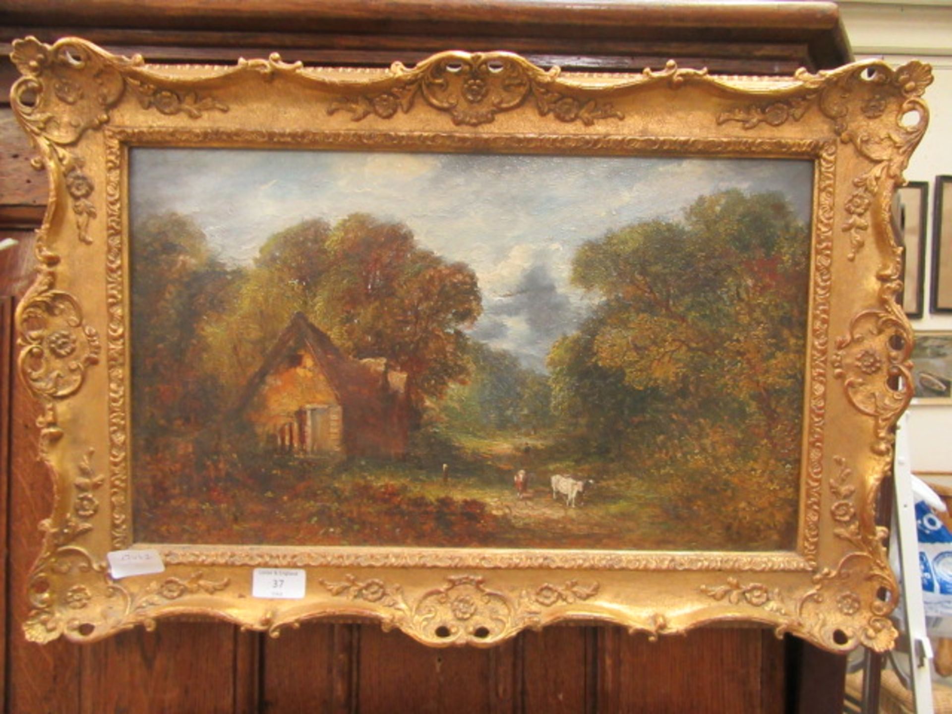 An ornate gilt framed oil on canvas of cottage scene