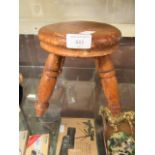 A small wooden four legged milking stool