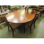 A mid-20th century teak extending dining table along with a set of four matching chairs