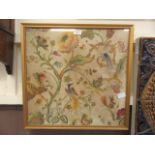 A framed and glazed possible 18th century crewel work panel depicting birds, flowers,
