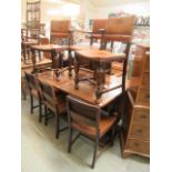 A mid-20th century extending refractory style table with a set of five standard chairs and one