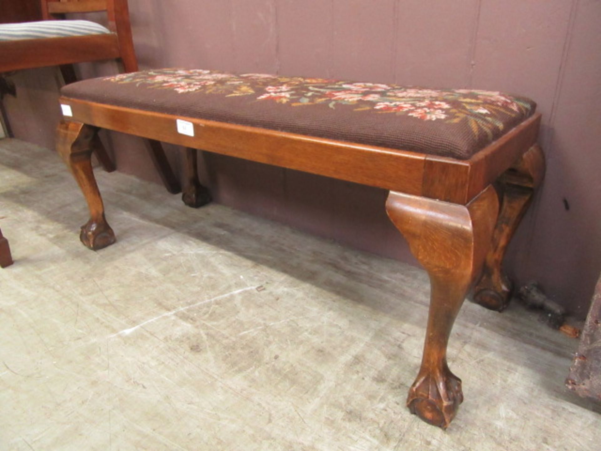 A reproduction walnut and beech stool on cabriole legs with ball and claw feet