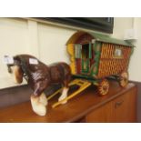 A hand crafted wagon together with a ceramic shire horse