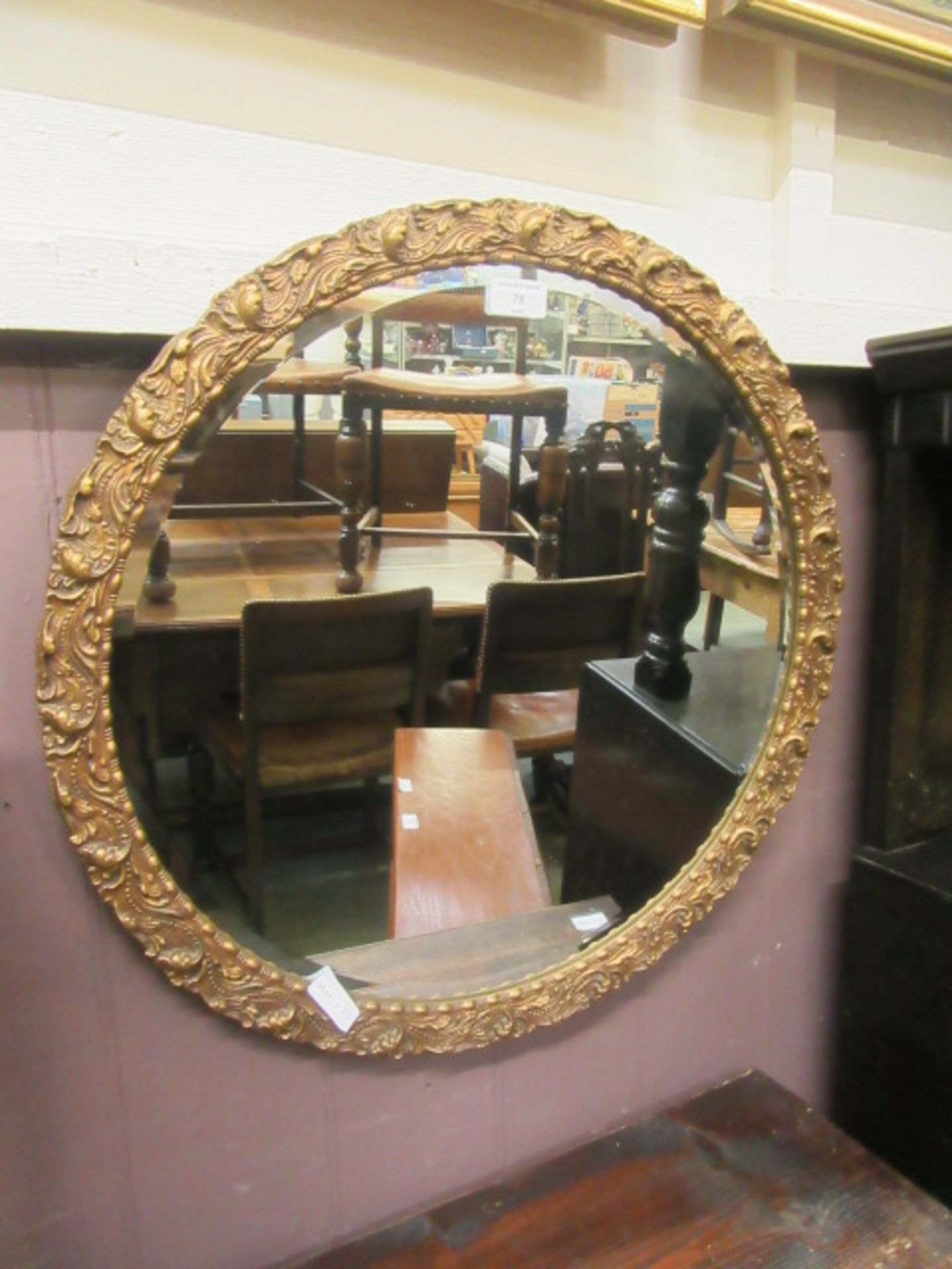 An ornate circular gilt framed bevel glass mirror