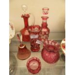 A collection of red glass and cranberry glass ware to include decanters, vases, bell,