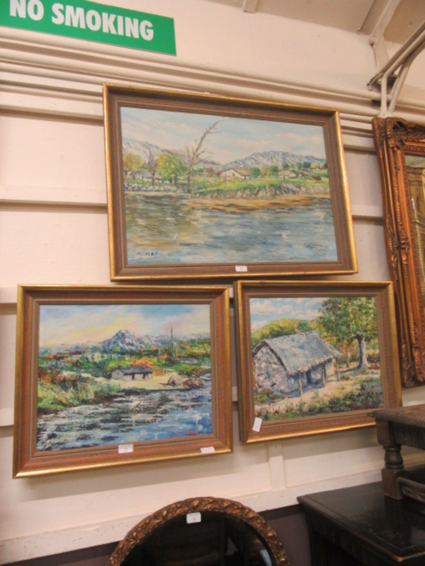 Three framed and glazed oils on board of village scenes signed M.