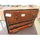 A small wooden three drawer cabinet containing a quantity of tools