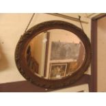 An ornate oval bevel glass mirror
