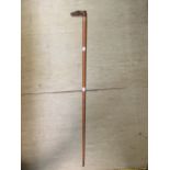 A walking cane with a carved wooden horse handle