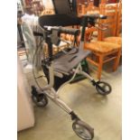 A grey and black tubular four wheeled walking aid