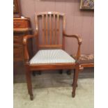An Edwardian mahogany and strung open armchair