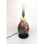 A Moorcroft table lamp decorated in a leaf design on a yellow ground, h.