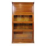 An early 20th century oak sectional bookcase comprising of cornice and plinth,