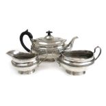 A George V silver three piece tea set having banded decoration.