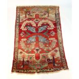 A handwoven Turkish rug, the border surrounding a red ground field with floral motif's,