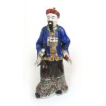 A 20th century Chinese polychrome porcelain figure of a standing dignitary.