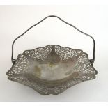 A George VI silver basket with scrolling pierced decoration and swing handle.